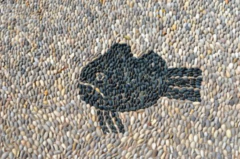 Grumpy fish pebbles mosaic on the floor on Rhodes island Stock Photos