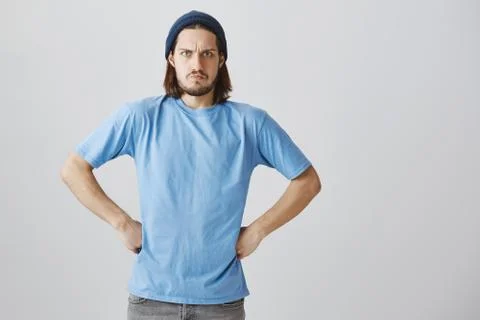 Grumpy guy is angry and disappointed. Portrait of funny furious guy with long Stock Photos