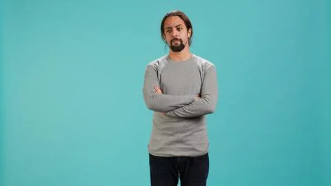 Grumpy man crossing arms, feeling upset by events Stock Photos