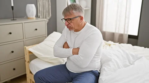 Grumpy middle age man, grey-haired, skeptic and nervous, wearing pyjamas in.. Stock Footage 271076509