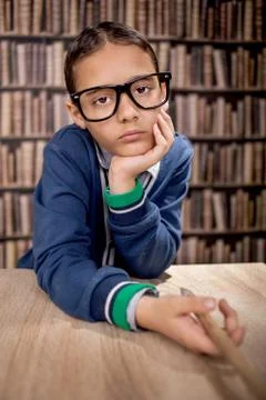 Grumpy young boy in library Stock Photos