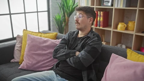 Grumpy young hispanic man with a moustache, skeptically crossed arms on liv.. Stock Footage 272913658