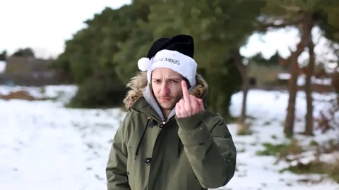 A grumpy young man wearing a black Bah Humbug Christmas hat Stock Footage 161647344