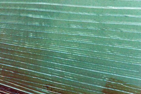 Grunge background: long parallel cracks on emerald glass 库存照片