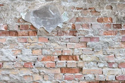Grunge background from an old brick wall with fallen plaster Stock Photos