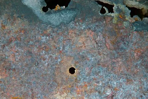 Grunge background: rust on an old painted metal surface, holes from through c Stock Photos