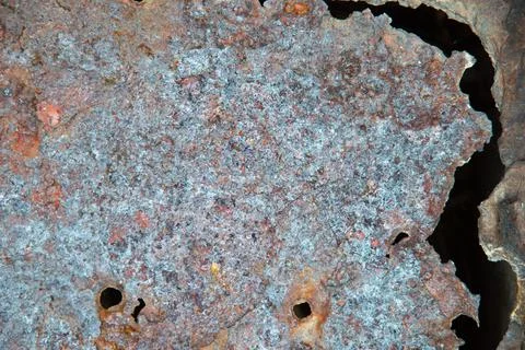 Grunge background: rust on an old painted metal surface, holes from through c Stock Photos