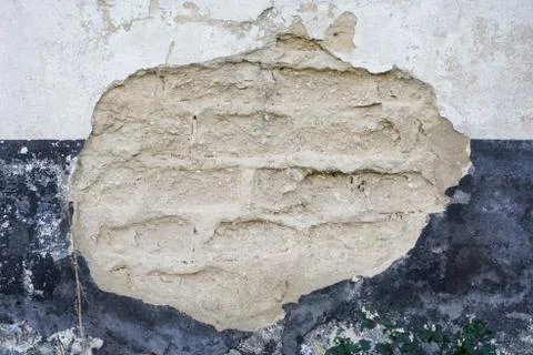Grunge background texture with adobe bricks exposed in a hole in an old wall Stock Photos