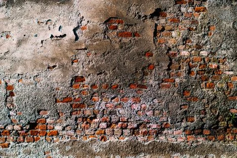Grunge background with texture of old brick wall and cracked dirty plaster Stock Photos