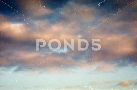 Grunge image of evening sky with clouds on grainy film texture Stock Photos