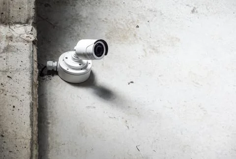 Grunge security camera with shadow on the public cement concrete wall background Stock Photos