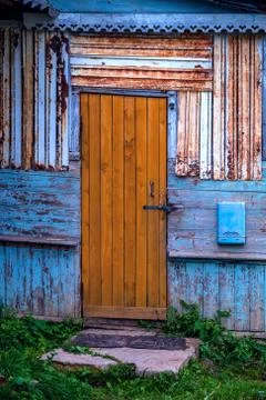 Grunge style background image, old wooden brown door on a contrasting blue sh Stock Photos