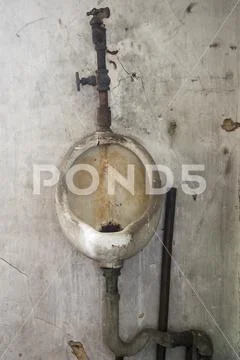 Grunge urinal on concrete wall Stock Photos