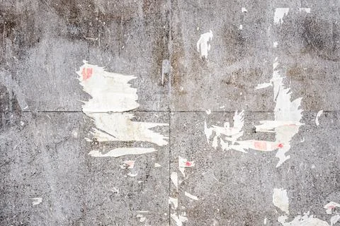 Grungy grey tiled wall texture featuring paper scraps and urban wear. Ideal.. Stock Photos
