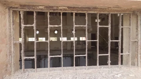 Grungy metal bars on a broken window of an abandoned industrial building Vídeos de archivo 332580071