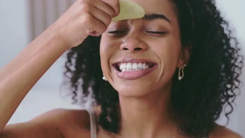 Gua Sha face lifting massage concept. Young african american woman massaging Stock Footage 238628493