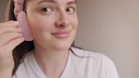Gua sha massage is an effective way to reduce morning puffiness and enhance skin Stock Footage 304890310