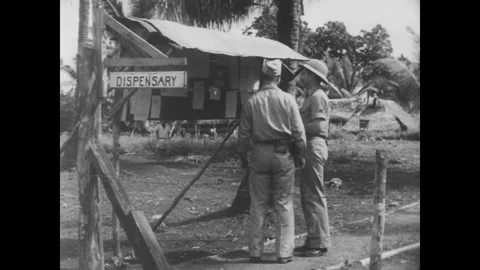 GUAM - 1944 - A Private First Class standing beside a bulletin board salutes to Stock Footage 340580325