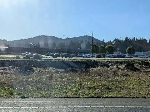 Guard tower and prison complex viewed from a roadside parking lot Stock Photos