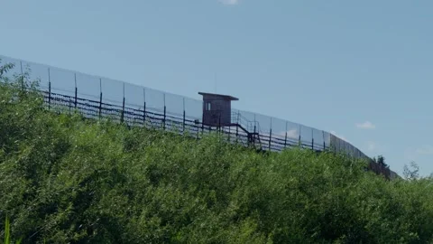 Guard watchtower and high security fence border on grassy hill at Daugavpils 库存影片 340892607