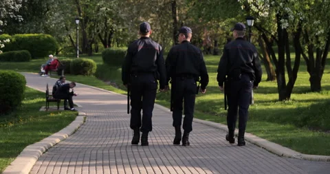 Guardians: Back View Perspective Three Police Officers Patrolling Park in Summer Stock Footage 241206414