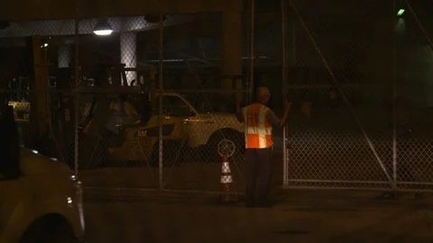 Guards opening the gate while tourist car arrives at the port entrance at night Stock Footage 116416350