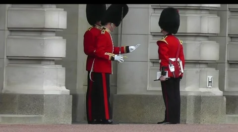Guards with swords reading a document at Buckingham Palace in London Stock Footage 55232232