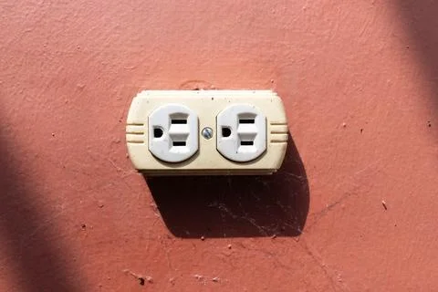 Guatemala electrical outlet on rustic red wall with dramatic shadows Stock-Fotos