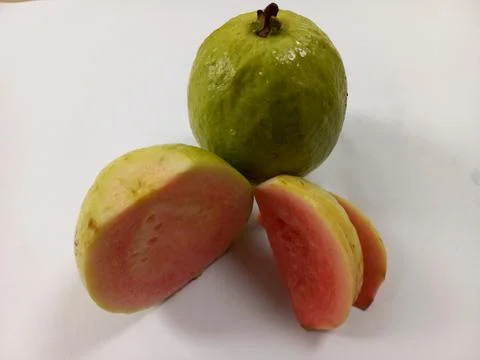 Guava fruit, a half and a slice with pink flesh isolated on white background Fotos Stock