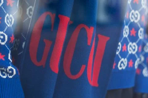 Gucci logo on blue pullover in luxury fashion store showroom 스톡 사진