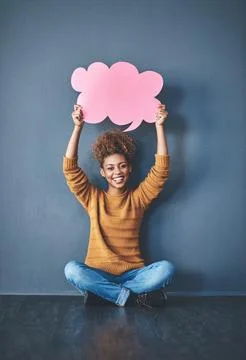 Guess what Im thinking. Studio shot of a young woman holding a thought bubble Stock Photos