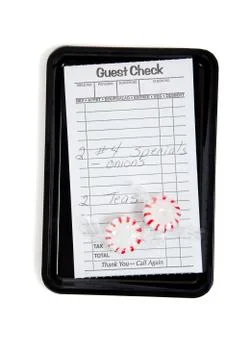 A guest check on a tip tray with mints on white Stock Photos