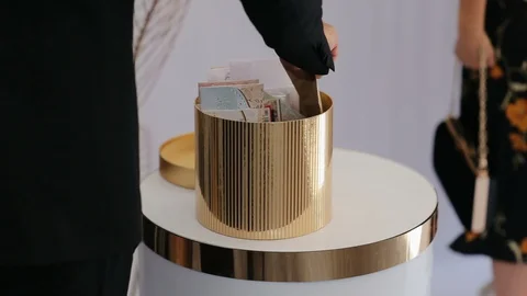 The Guest puts the envelope with money inside into basket with money gifts for Stock Footage 128212762