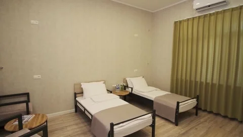A guest room with two beds in a small cozy hotel Stock Footage 262851336
