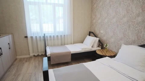 A guest room with two beds in a small cozy hotel Stock Footage 277333077