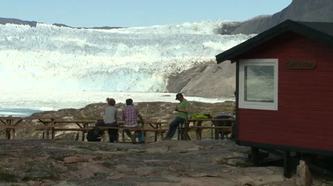 Guests being served at café in front of huge glacier adventure tourism Stock Footage 59999895