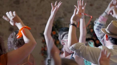 Guests dancing at a wedding reception, arms raised, in a room with Stock Footage 317133614