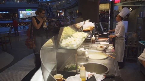 Guests examining meal options at food court in Shoppes at Marina Bay Sands Stock Footage