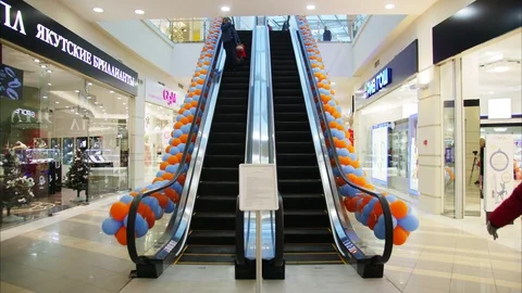 Guests use escalators decorated with balloons in trade mall Video stock 127749928