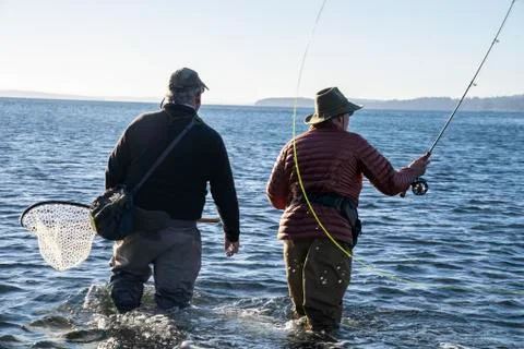 A guide advises his client while fly fishing in salt water for searun coastal Stock Photos