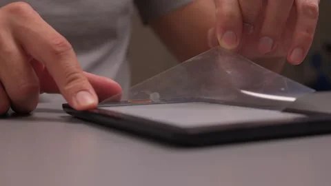 This guide explores how to apply a screen protector on a tablet carefully and Stock Footage 316963541