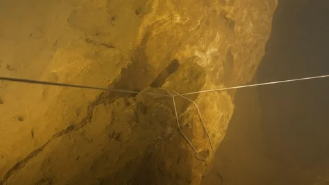 Guide line anchored to the rock pulled by diver, Risorgenza Amaseno, Italy Stock Footage 108978310