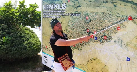 The guide on the map shows and tells the story of the origin of the city of Stock Footage 118234719