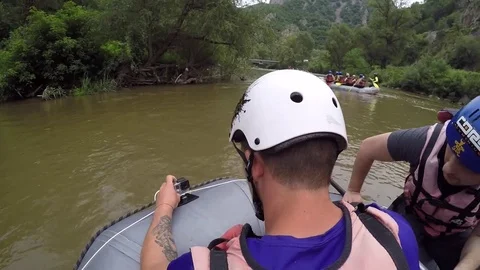 Guide setting up GoPro action camera before rafting with friends starts Stock Footage 78743765