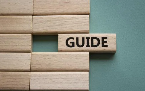Guide symbol. Concept word Guide on wooden blocks. Beautiful grey green bac.. Stock Photos
