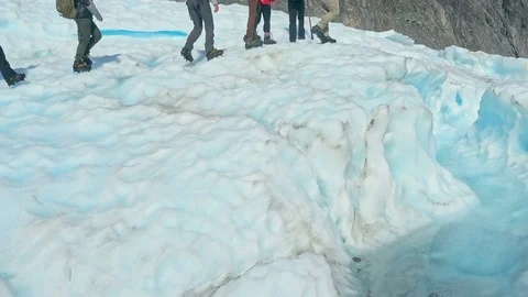 Guide Walking through glacier tunnel with guide using ice pick. Stock Footage 79429626