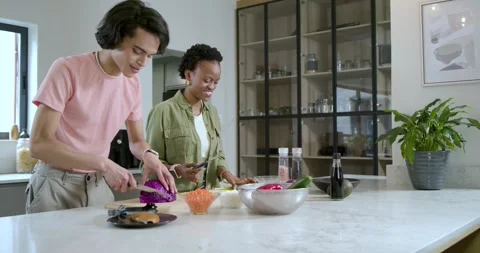 Guided by gesture diverse friends chopping cabbage, slicing cucumber at marble Stock Footage 341937540