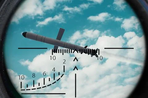 Guided missile seen through targeting scope against blue cloudy sky Stock Photos