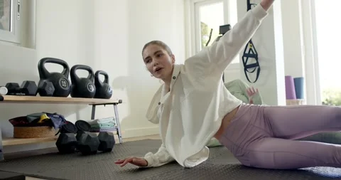 Guided by routine, female friends moving side plank into spinal twist on foam Stock Footage 338167832
