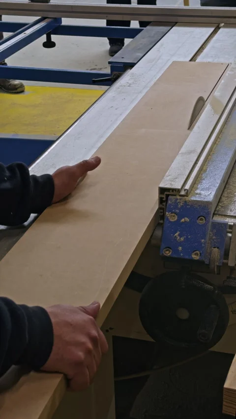 Guiding a Wooden Board Through a Table Saw Stock Footage 337551937